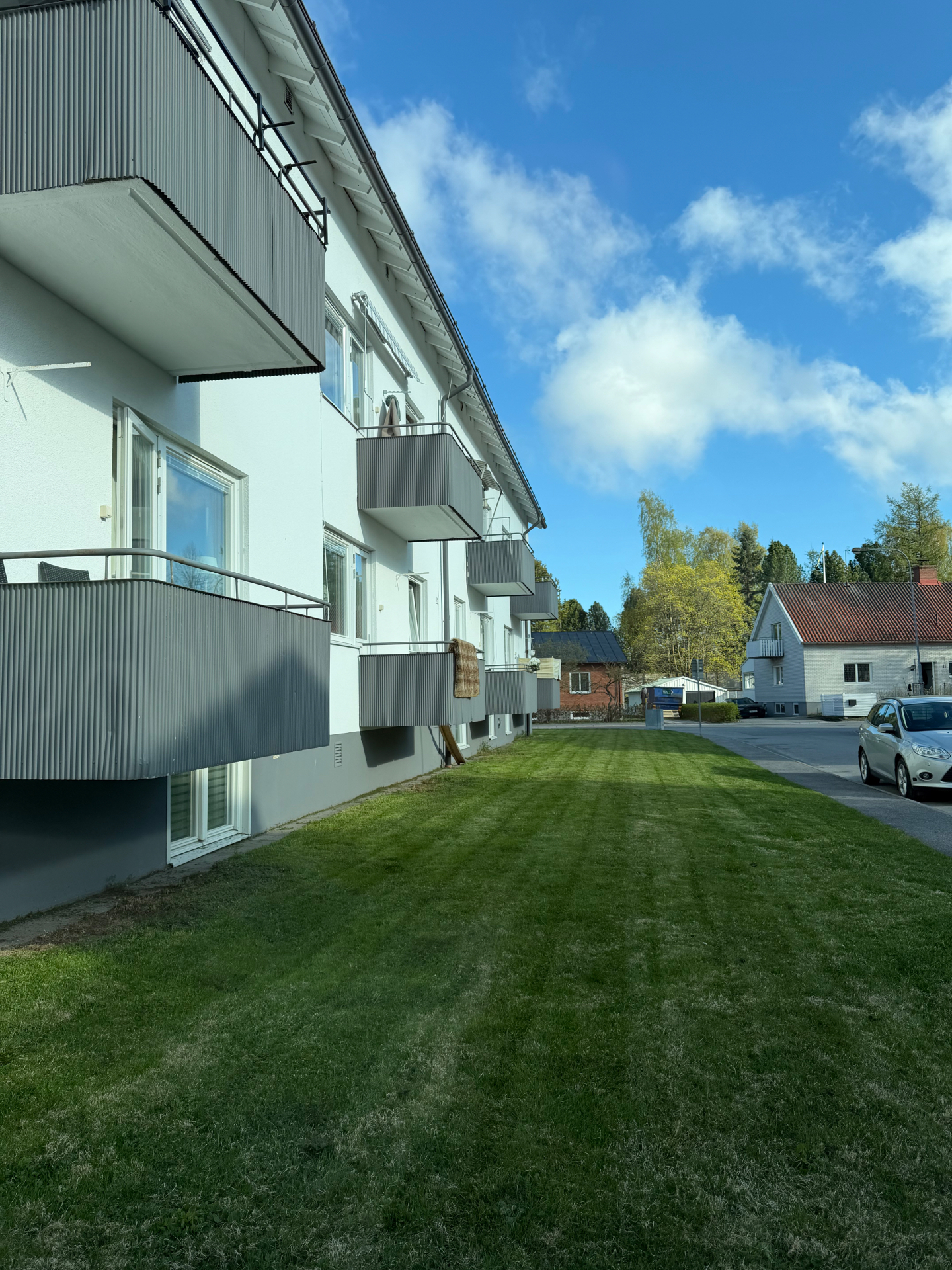 Fasaden från sidan med balkonger och gräsmatta